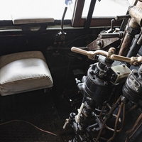 蒸気機関車の機関室内にある運転席と操作機器の写真