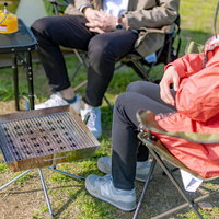 オートキャンプ場のテントサイトでくつろぐ二人組の写真