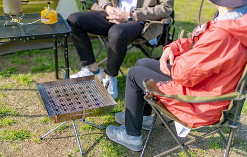 オートキャンプ場のテントサイトでくつろぐ二人組