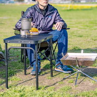 晴天のオートキャンプ場でソロキャン、キャンプテーブルでくつろぐ男性の写真