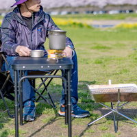 キャンプ場のチェアでくつろぐソロキャンパーの後ろ姿の写真