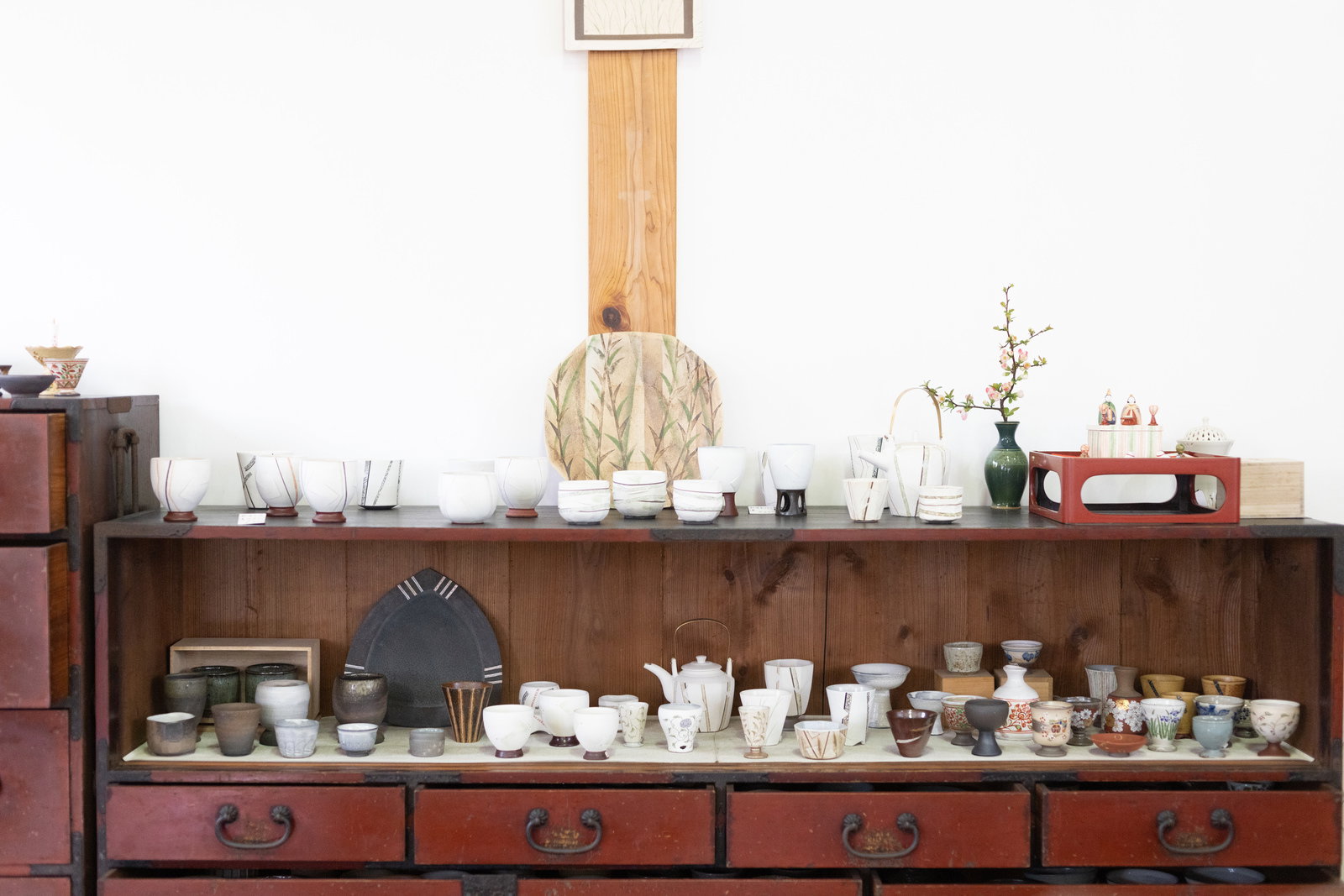 木製の棚に陶器の茶碗や湯呑みが並んでいる工房の様子