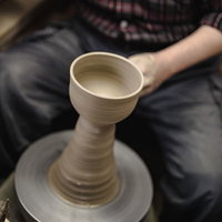 ろくろを回して器を成形する陶芸職人の手元の写真