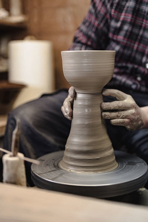電動ろくろを回す職人の手さばき、陶土を成形する様子