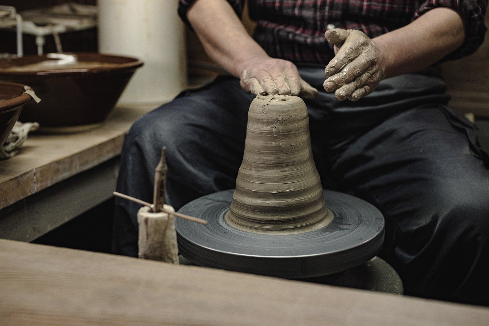 ろくろを使って陶器を成形している職人の手元作業風景