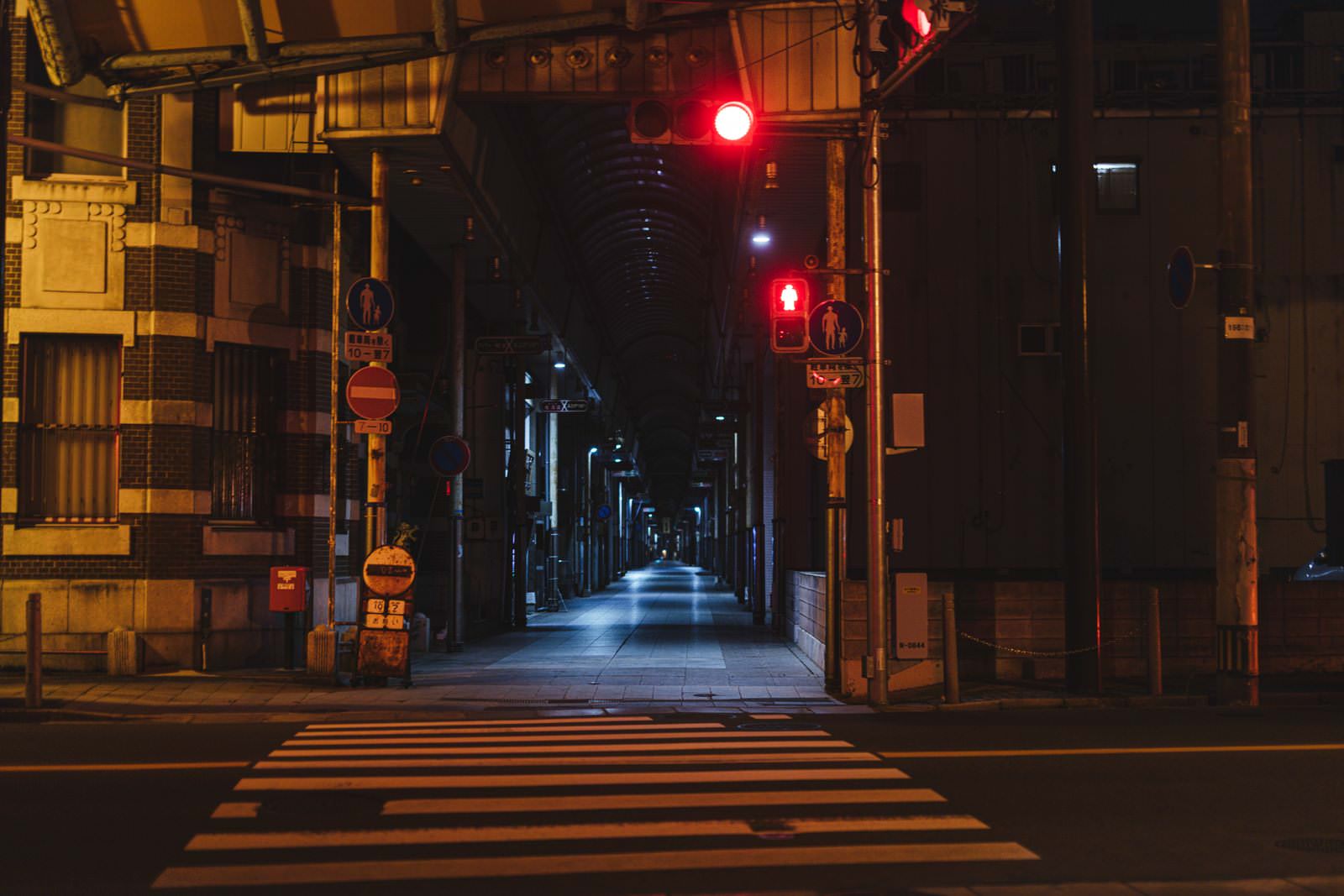 深夜の直方市古町商店街、赤い信号機と横断歩道が映る夜景