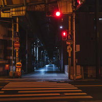 深夜の直方市古町商店街、赤い信号機が照らすアーケード街と横断歩道の写真