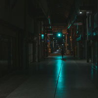 青信号の光が伸びる深夜の直方市古町商店街のシャッター通りの写真