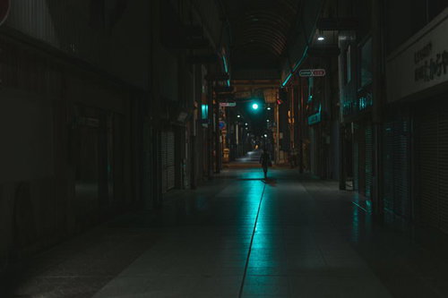 青信号の光が伸びる深夜の直方市古町商店街のシャッター通り