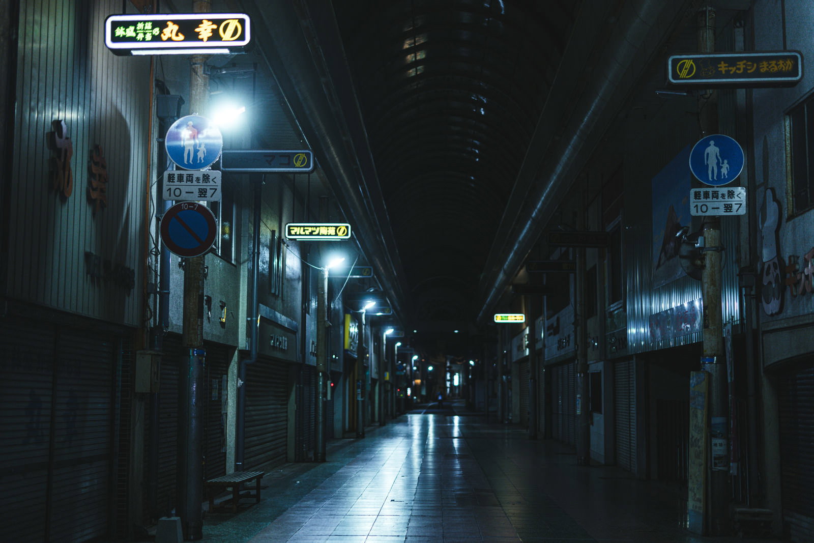 街灯に照らされた夜の商店街の歩道風景