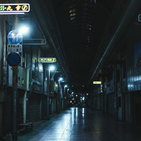 夜の商店街（とのまち通り）の街灯と歩道、店舗看板の写真