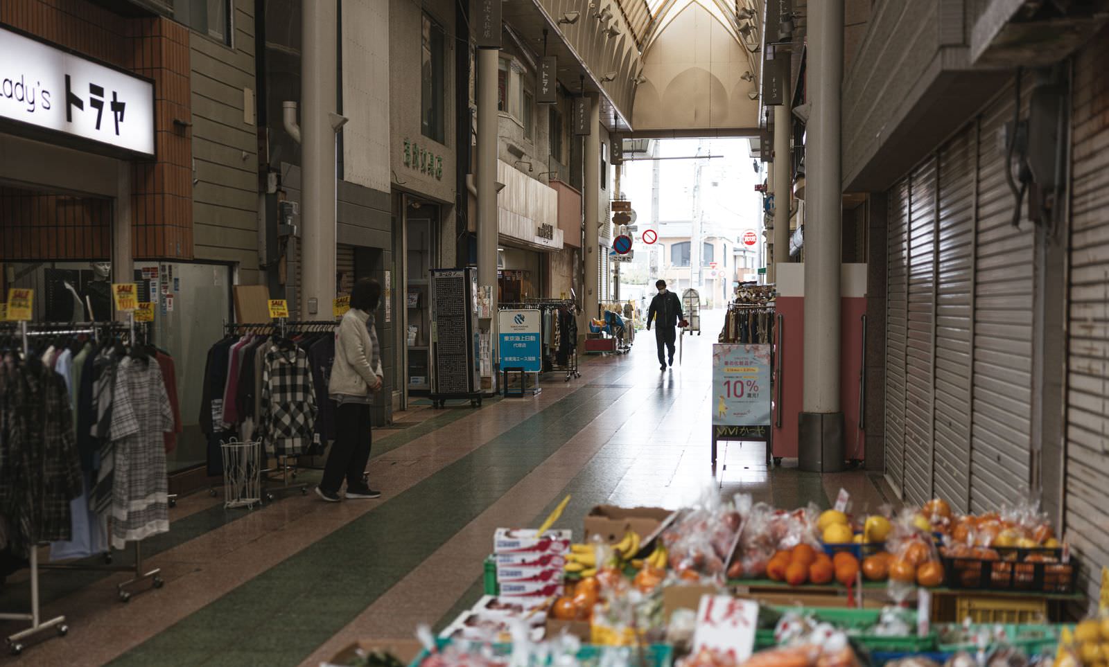 アーケード屋根の下に店舗が並ぶ商店街の通路