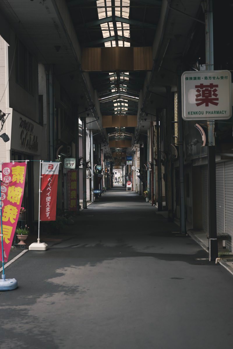 昼過ぎの直方須崎町商店街アーケード内の薄暗い通路