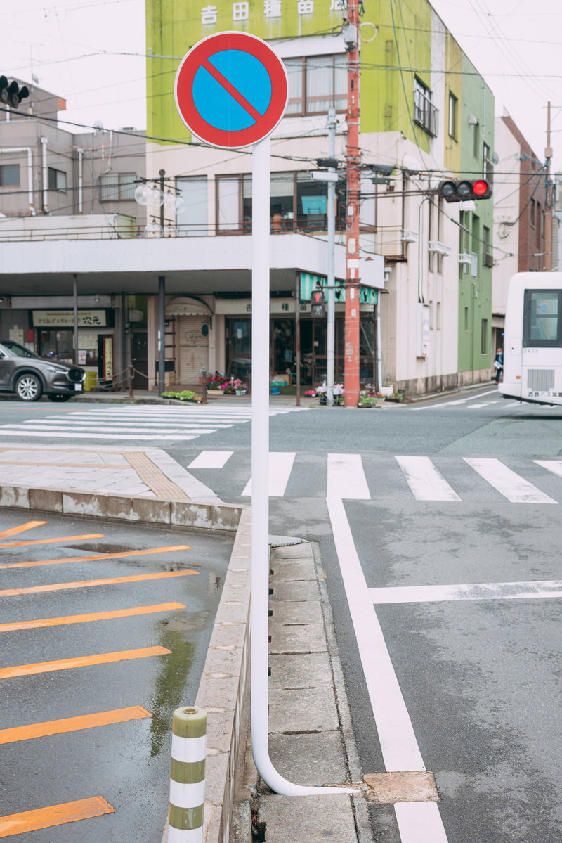 交差点の道路に設置された根元がL字に曲がった青い駐車禁止標識