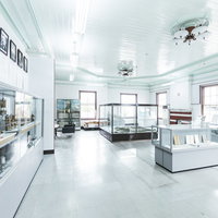 直方市石炭記念館本館の展示室に並ぶ複数の展示ケースの写真