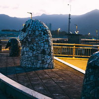 朝を待つ直方市の日の出橋に並ぶフクロウ像と夕暮れの景観の写真