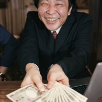 お客様の声で儲かったアピールするスーツ姿の男性の写真