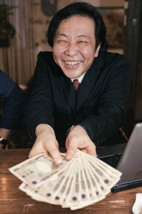 お客様の声で儲かったアピールするスーツ姿の男性