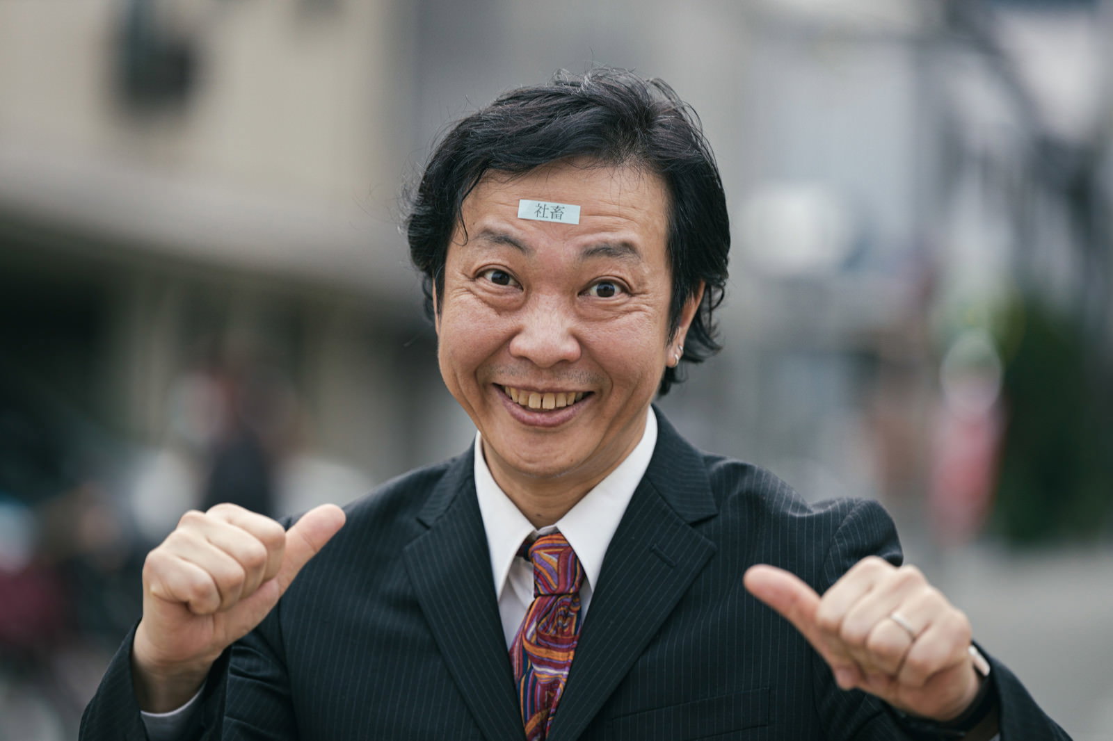 黒いスーツを着てガッツポーズする笑顔の男性会社員［モデル：のせさん］
