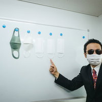 マスクを販売する怪しいバイヤー男性がスーツで説明の写真