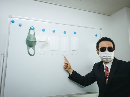 マスクを販売する怪しいバイヤー男性がスーツで説明