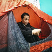 家に帰れないのでテントで暮らす会社員男性の写真