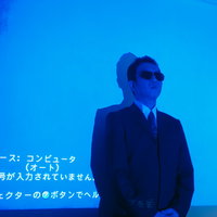 プロジェクターの前で邪魔なんでどいてくれませんかと言うスーツ姿の男性の写真