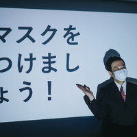 マスク着用を呼びかけるビジネスマンの研修風景の写真