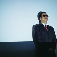 不気味な笑顔で威圧する鬼教官・サングラスをかけたスーツ姿の上司の写真