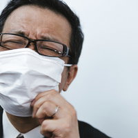 マスクが息苦しくて耐えきれない会社員男性の写真