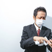 また非通知だよ... 着信拒否と向き合うスーツ姿の営業マンの写真