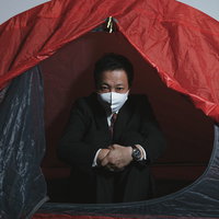 赤いテントで泊まる社畜会社員のマスク姿の写真