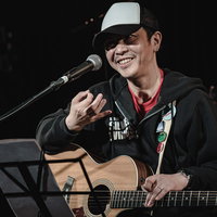 チケット完売でガッポガッポ、ライブハウスで熱唱するボーカルギタリストの写真