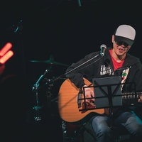シークレットライブでアコギの新曲を披露する男性ボーカルの写真