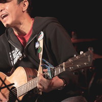 アコギを持ってライブハウスで演奏する男性の写真