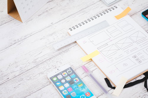 ノートにワイヤーフレームを手書きするデザイナー