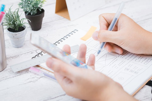 スマホビューをチェックしながらワイヤーフレームを書くデザイナー