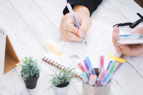 スマホで確認しながらワイヤーフレームを設計するディレクター