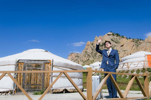 モンゴルのゲル前で手を振るビジネスマン