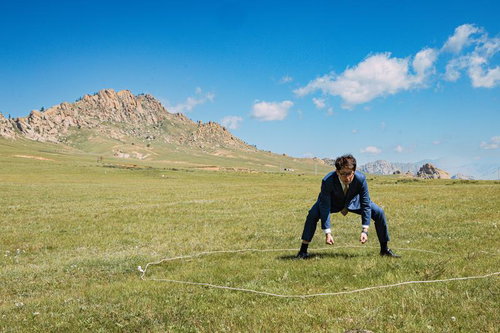 モンゴルの大草原でスーツ姿の男性が四股を踏む瞬間