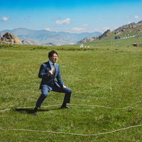 モンゴルの大草原で闘志をみなぎらせるビジネスマンの写真