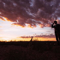 モンゴルの草原で夕焼けに染まるビジネスマンのシルエットの写真