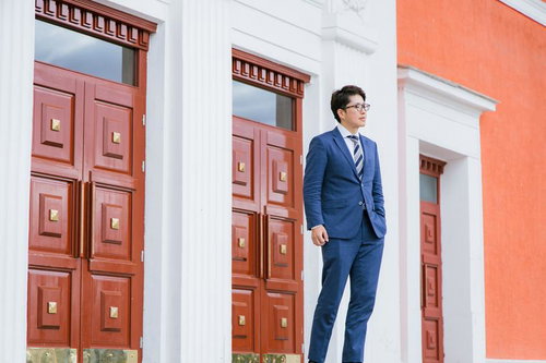 世界銀行の赤い扉の前に立つスーツを着たビジネスマン