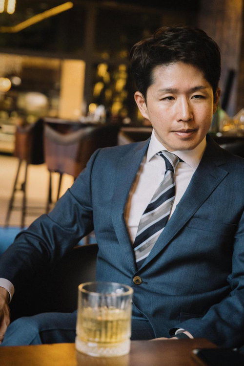 ウイスキーグラスを前にバーで商談する会社員