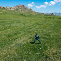 モンゴルの広大な草原に佇むスーツ姿のビジネスマンの写真