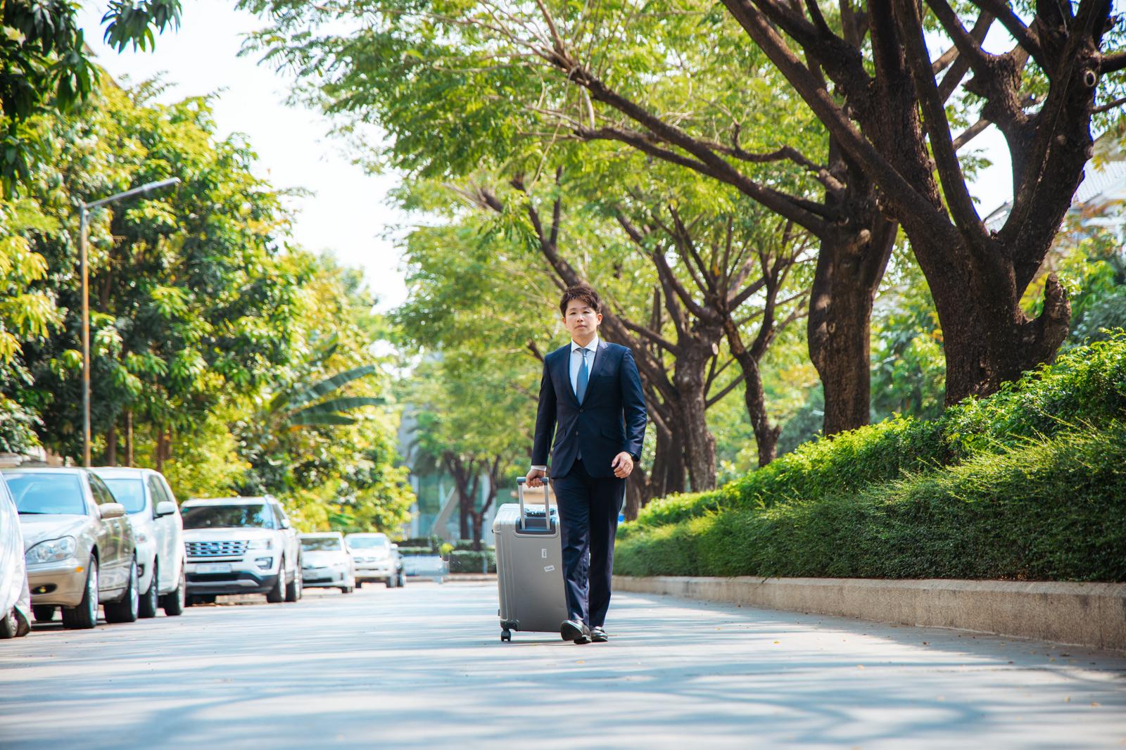 台北の街で濃紺スーツを着たビジネスマンが立っている［モデル：野崎繁裕］