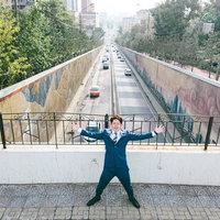 モンゴルの都会を背景に両手を広げてポージングする男性の写真