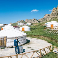 モンゴルのゲルから出社をキメるビジネスマンの写真