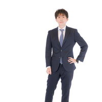 紺色スーツで立つM&Aアドバイザーの男性の写真