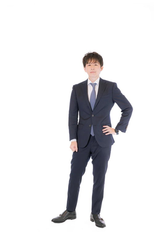 紺色スーツで立つM&Aアドバイザーの男性